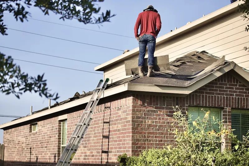 Professional roofer working on a residential roof in Elmhurst